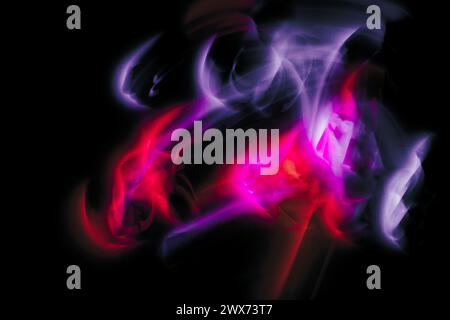 Abstract irregular purple and red light on black background. Long exposure. Light painting photography. Stock Photo