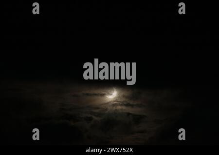 A narrow semicircle of the moon in cloudy cloudy weather. Sickle, crescent moon at dusk to overlay on your photos. Natural evening background Stock Photo