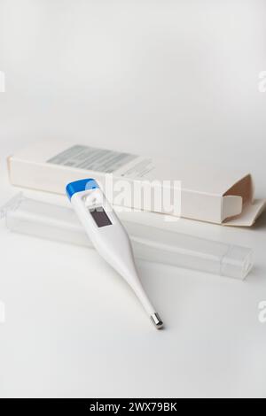 modern digital thermometer with box and plastic cover, electronic device used to measure temperature accurately and display the readings digitally, mo Stock Photo