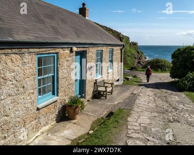 Cove Cottage, an old Cornish granite stone cottage with blue wooden door and sash windows overlooking Porthgwarra Cove, Cornwall, England, UK Stock Photo