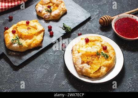 Sweet pie with orange caramelized slices on black stone background. Stock Photo