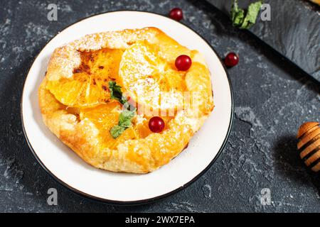 Sweet pie with orange caramelized slices on black stone background. Stock Photo