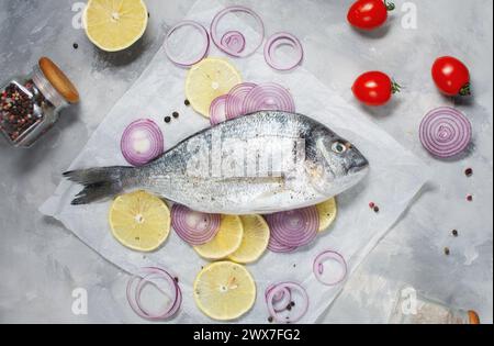 Raw dorado fish on cutting board on concrete table with ingredients for cooking. Top view Stock Photo