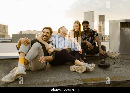 Cheerful group of male and female friends having fun while sitting on terrace Stock Photo