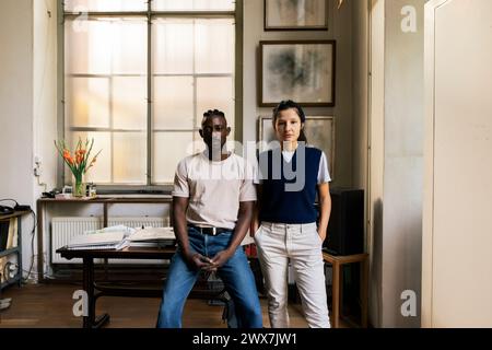 Portrait of confident multiracial male and female colleagues in workplace Stock Photo
