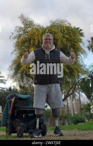 a man with no legs, he finds the strength to stand up, with the help of his orthopedic legs, leaving the wheelchair behind him. Stock Photo