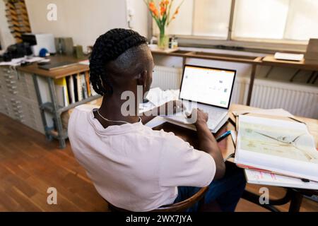 Businessman using laptop while working at table in home office Stock Photo