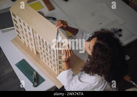 High angle view of female construction engineer preparing building model at desk in office Stock Photo