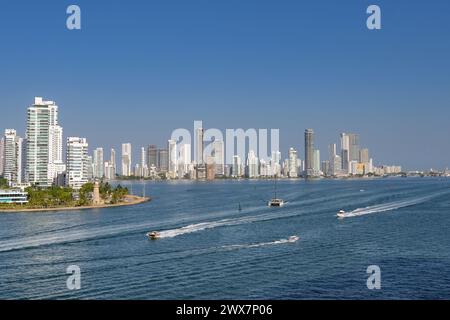 Cartagena, Colombia - 24 January 2024: Boats passing the Naval Club and lighthouse at the entrance to the city's port Stock Photo