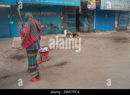 A cleaning worker of the city corporation, is seen sweeping the streets at Morning in the Khulna, Bangladesh. Stock Photo