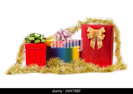 Three red boxes with bows and golden tinsel. Isolated over white background. Close-up. Stock Photo
