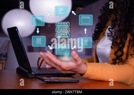 Business woman works on laptop with glowing hologram of file search on server. Cloud computing, big data backup concept. out of focus background. Stock Photo