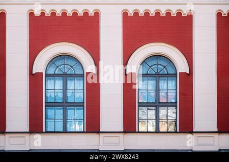 Two arched windows with gray frames against a red brick wall with columns. From the series Window of the World. Stock Photo