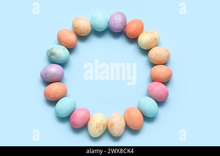 Frame made of painted Easter eggs on blue background Stock Photo