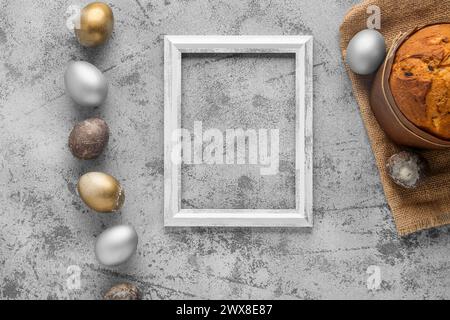 Empty frame, painted eggs and Easter cake on grey grunge background. Top view Stock Photo