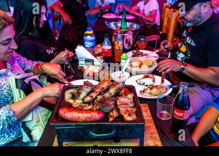 People Eating A Traditional Asado/Barbecue Meal A Restaurant In The La Boca District of Buenos Aires, Argentina. Stock Photo