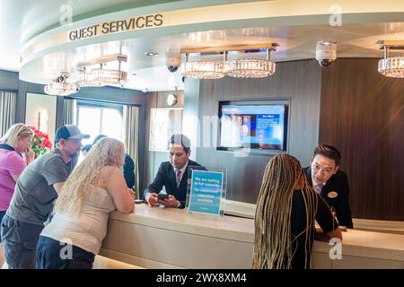 Miami Florida,PortMiami Port of Miami,onboard inside interior,Norwegian Joy Cruise Line ship,7-day Caribbean,Guest Services counter,man men male,woman Stock Photo