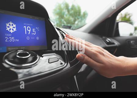 Air conditioning in the car. Cold air.. Driver hand tuning air ventilation grille Stock Photo