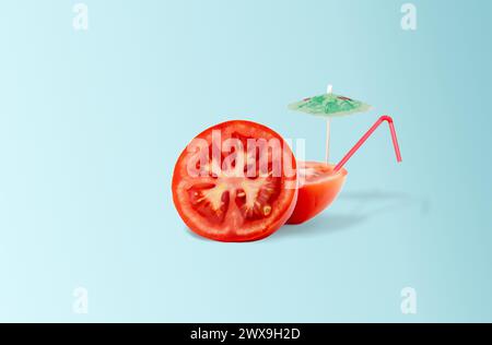 Tomato cocktail with straw and sun umbrella on light blue gradient background. Minimal summer tropical beach concept Stock Photo