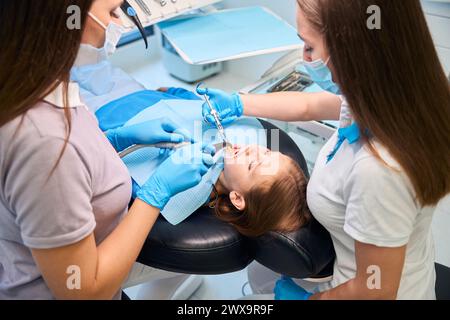 Doctor gives an injection with anesthetic to teenage girls gum Stock Photo