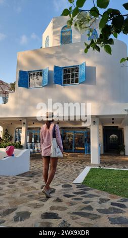Bangsaray Pattaya Thailand 28 February 2024, A stylish woman stands gracefully outside a pristine white building, exuding confidence and poise against the architectural backdrop. Stock Photo