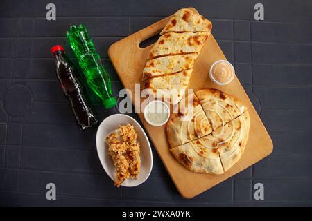 Mediterranean stuffed naan calzone quesadilla with chicken strips and drinks Stock Photo