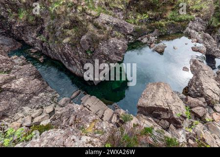 The emerald waters of the Fairy Pools glisten from above, set in a rocky embrace on the Isle of Skye, a natural jewel in the Scottish wilds Stock Photo