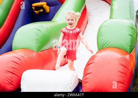 Happy child on inflatable bounce house at festival Stock Photo
