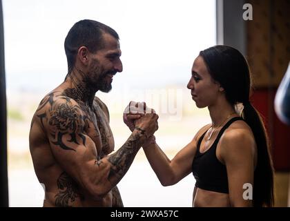 Happy couple holding hands while standing in gym Stock Photo