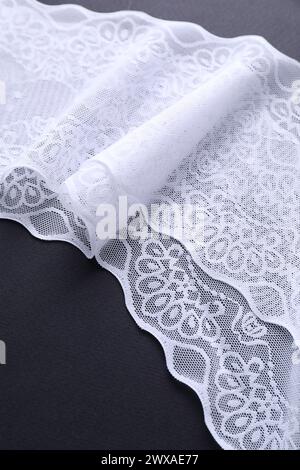 White lace on black background, closeup view Stock Photo