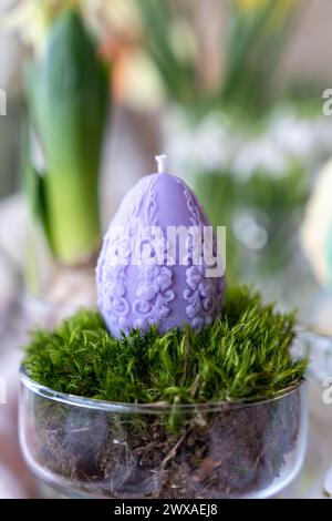 Colorful easter egg soy wax candle. Spring background Stock Photo