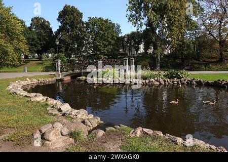 Decorative pond and small bridge with many padlocks in the City park Bastion Hill in Riga center on sunny day Stock Photo