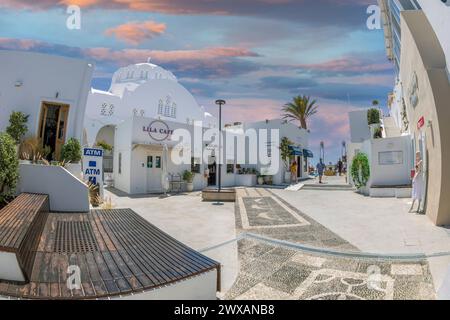 FIRA, SANTORINI, GREECE - JUNE 21, 2021: Small square with fashion shop, art galleries and restaurants near The Orthodox Metropolitan Church of Candle Stock Photo