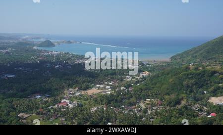 The view of the city of Central Lombok from above that can be seen with many houses and green areas and seascape Stock Photo
