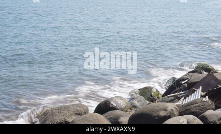 Ocean waves hitting the rocks with overexposure light at beach in Central Lombok Stock Photo