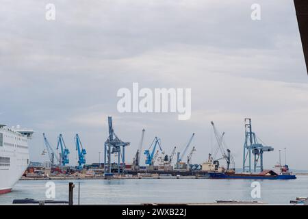 Ancona Italy - 20 Sep 2023: View of the port with many port cranes and a huge liner entering the port. Stock Photo