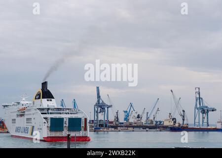 Ancona Italy - 20 Sep 2023: View of the port with many port cranes and a huge liner entering the port. Stock Photo