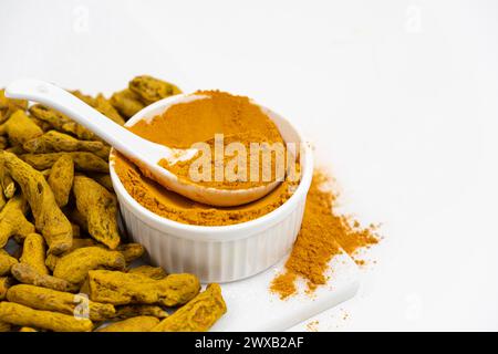 Turmeric powder, spices and dried root on white background Stock Photo