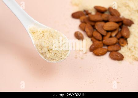 Almond flour and almonds on a beige background. Stock Photo