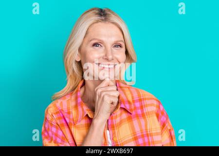 Photo of smart woman with straight hairstyle dressed checkered shirt think business hand on chin isolated on teal color background Stock Photo