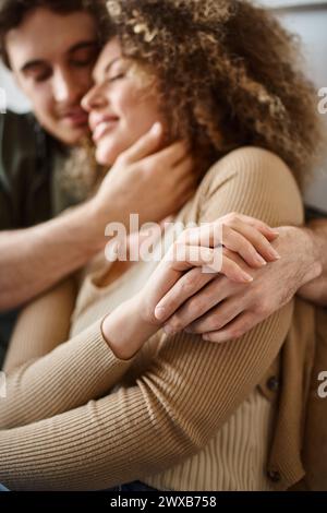 Closeup image of hands of curly young woman and brunette man sharing a heartfelt hug Stock Photo