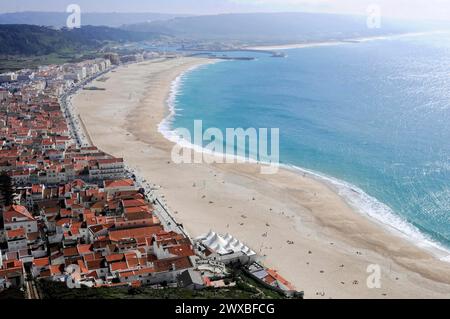 Beach from the village of Sitio, Nazare, Oeste, Leiria district, panoramic view of a wide coastline with beach and neighbouring buildings, Northern Stock Photo