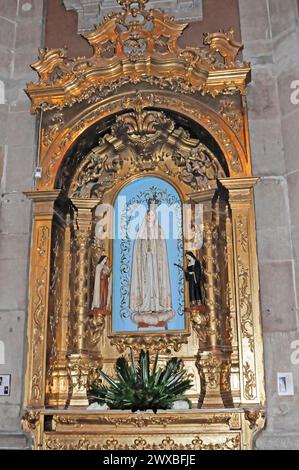 The church Igreja de Santo Ildefonso, Parca da Batalha, Porto, UNESCO World Heritage Site, gold-accentuated chancel with a blue-framed statue of the Stock Photo