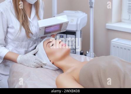 The cosmetologist uses the Wood Lamp for detailed diagnosis of the skin condition. The device detects the presence of skin diseases or inflamed areas. Stock Photo