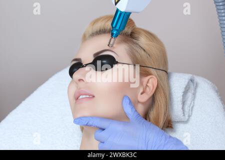 Laser tattoo removal on woman's eyebrows in a beauty salon Stock Photo