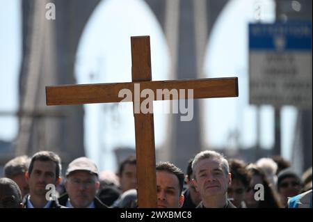 New York, USA. 29th Mar, 2024. In observance of Easter Holy Week, people walk along the Brooklyn Bridge as they attend 'The Way of the Cross' making their way from the borough of Brooklyn to Manhattan, New York, NY, March 29, 2024. The annual procession is held on Good Friday, emulating Christ's walk to Calvary. (Photo by Anthony Behar/Sipa USA) Credit: Sipa USA/Alamy Live News Stock Photo
