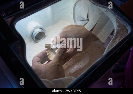 A dental technician polishes the details of a dental stone model with the handpiece to make it ready to work on. Stock Photo