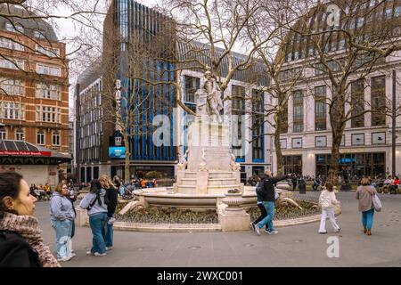 A statue of William Shakespeare has formed the centrepiece of Leicester Square Gardens in London since 1874. The iconic Odeon Luxe cinema to the rear. Stock Photo