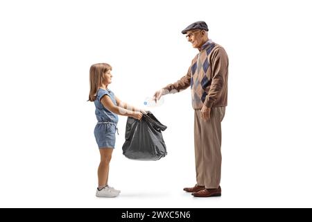 Full length profile shot of a senior man throwing a plastic bottle and little girl holding a waste bag isolated on white background Stock Photo