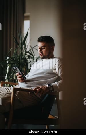 Young man enjoying a peaceful moment with smart phone at home Stock Photo